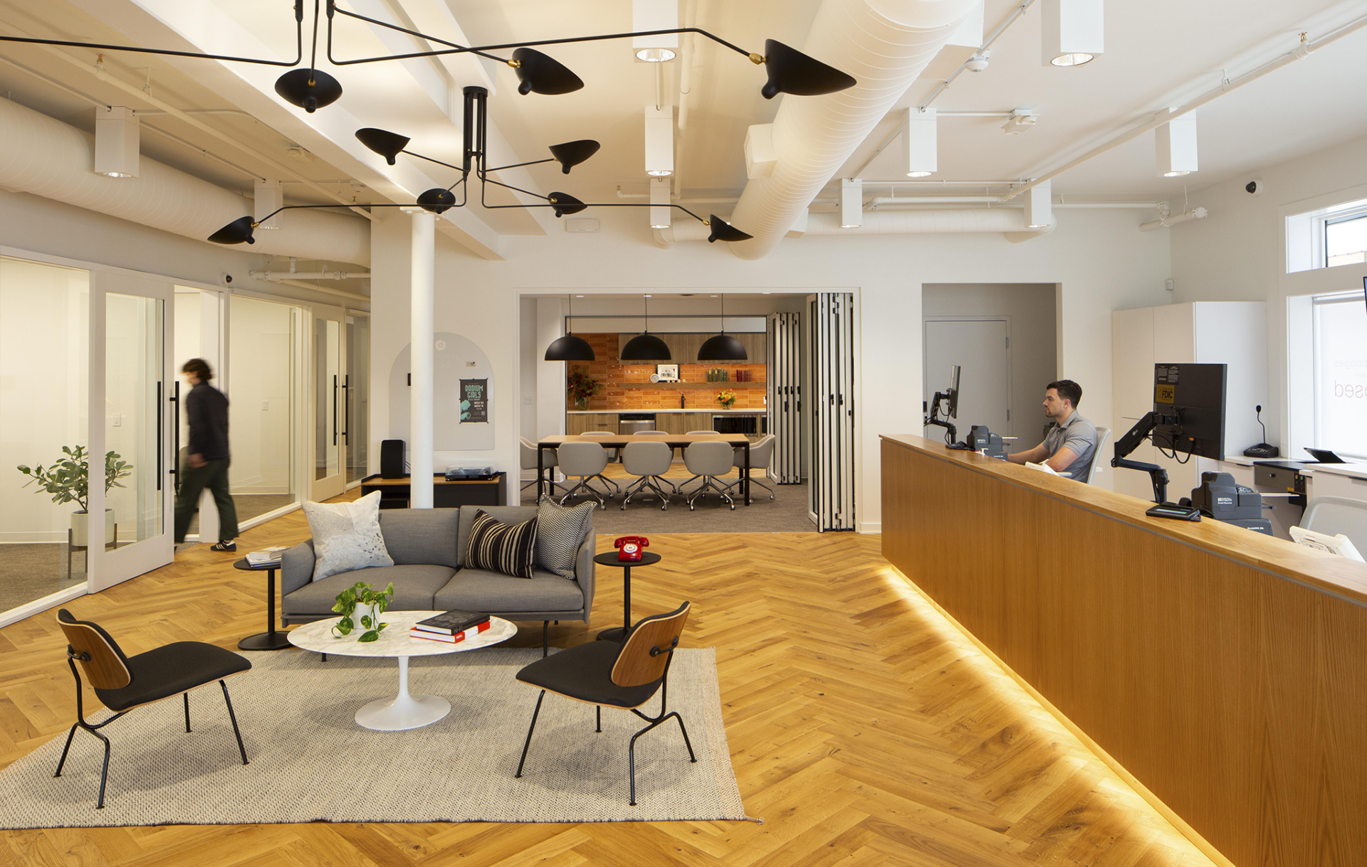 A bank lobby. Tellers to the right, a sitting area in the middle of the room and a conference room in back.