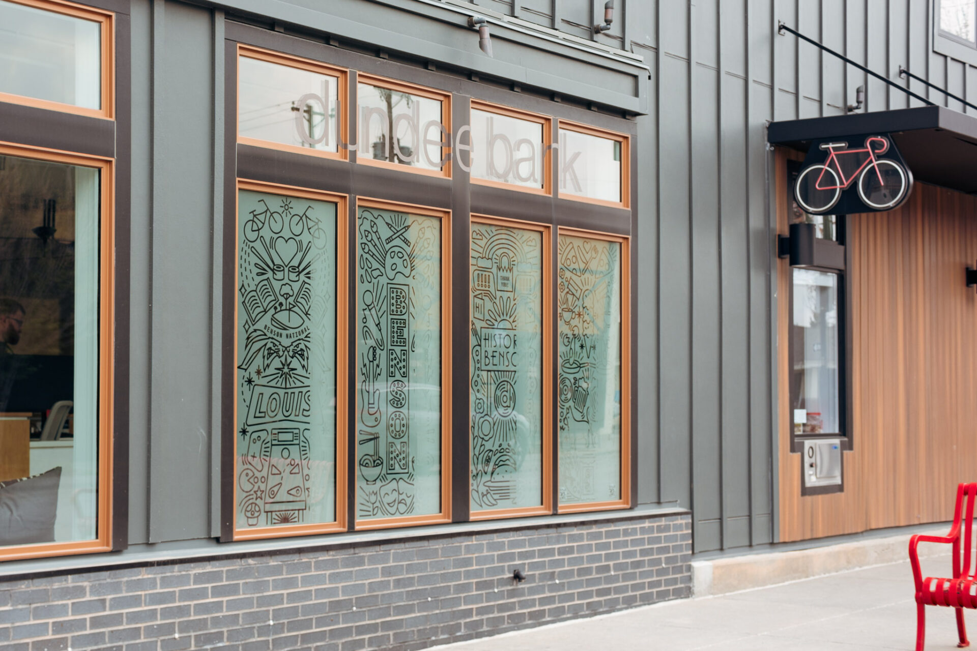 A building with four vertical windows with illustrations.